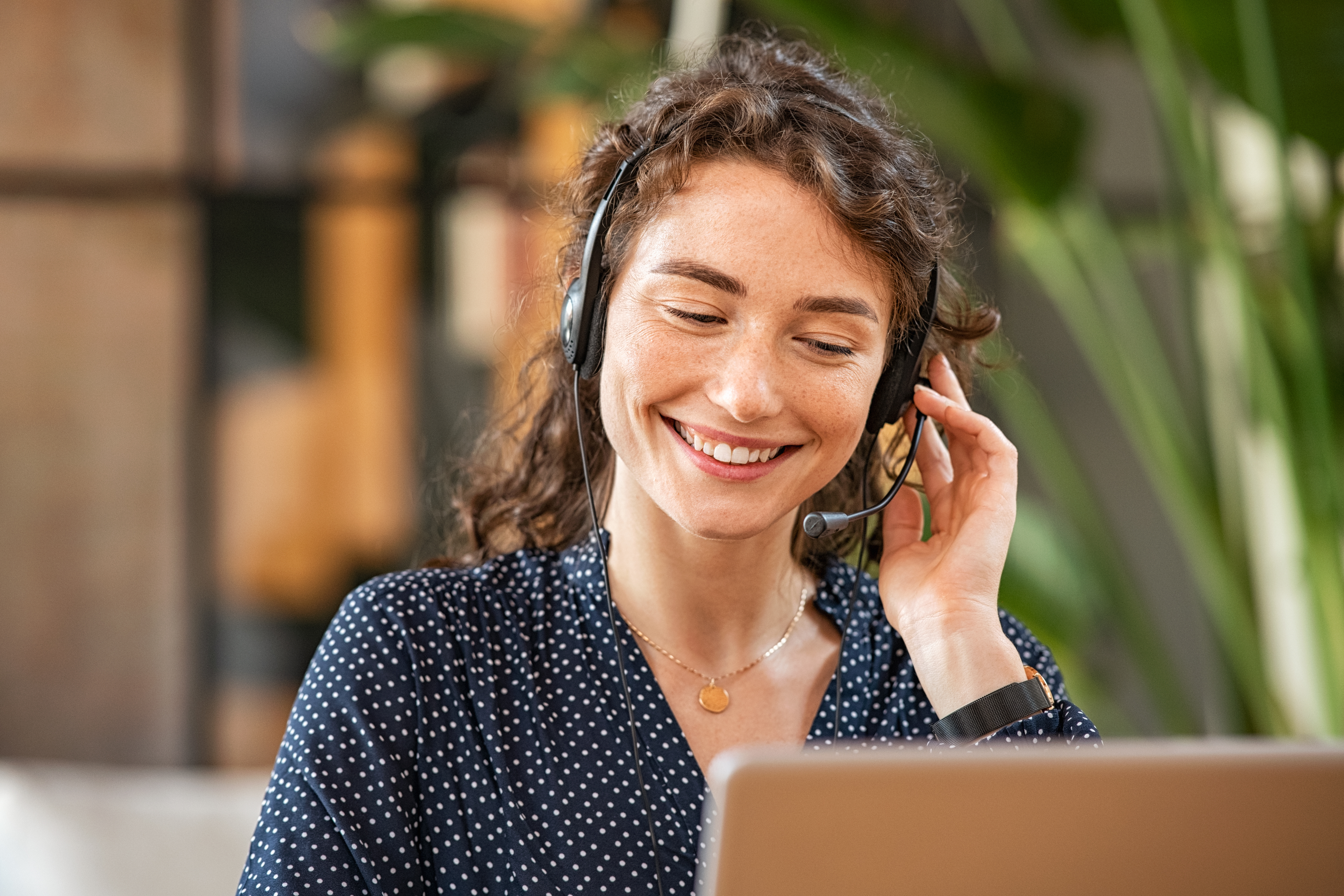 Dame som headset ved computer 